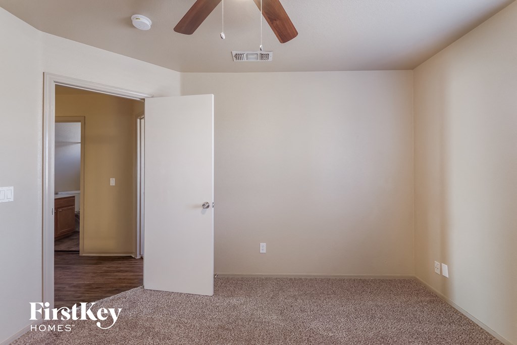a empty bedroom with a closet and a ceiling fan