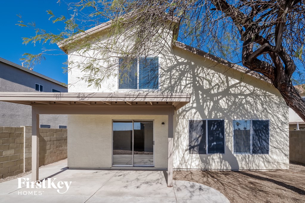 a white house with blue shutters and a tree