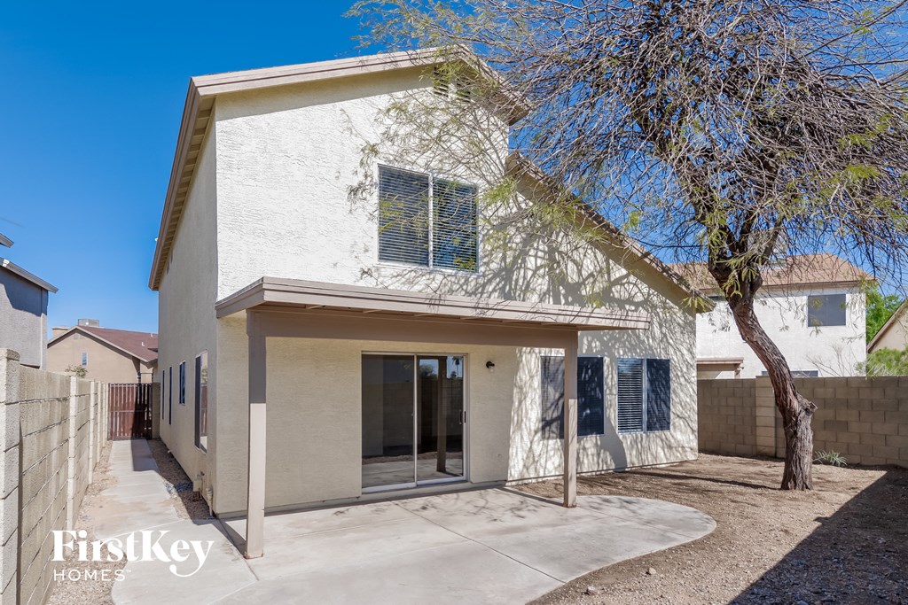 a white house with a tree and a driveway