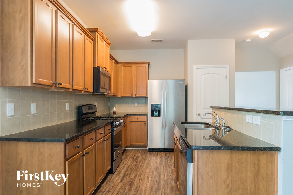 a kitchen with wooden cabinets and stainless steel appliances and a sink