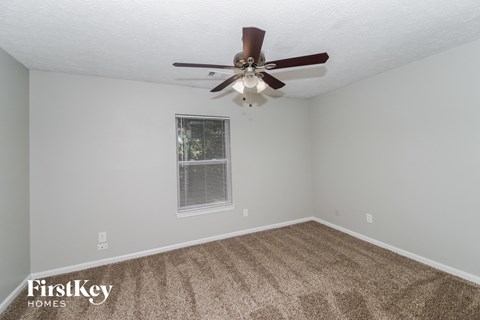 the living room of our studio apartment atrium with ceiling fan and carpet