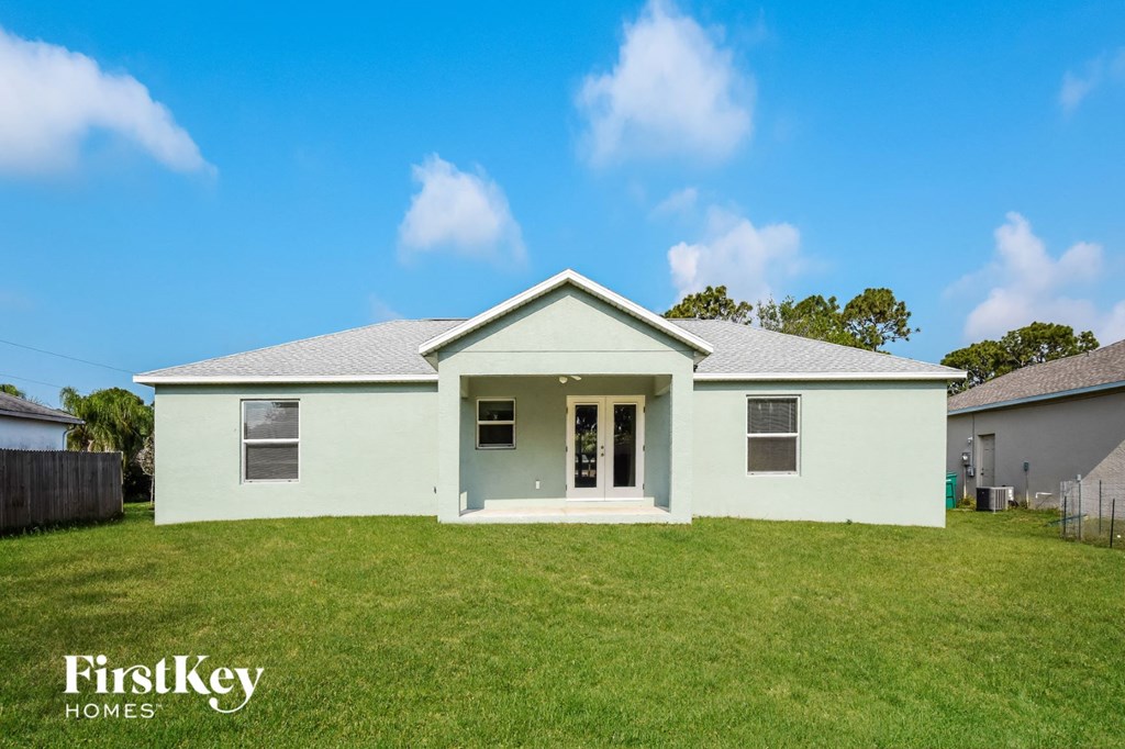 a white house with a green lawn and a blue sky