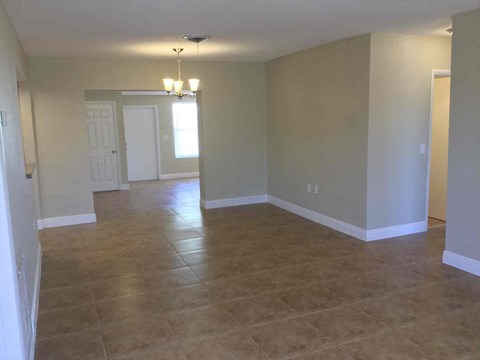 A room with tile flooring and a chandelier.