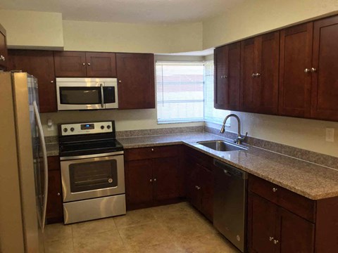A kitchen with brown cabinets and stainless steel appliances.
