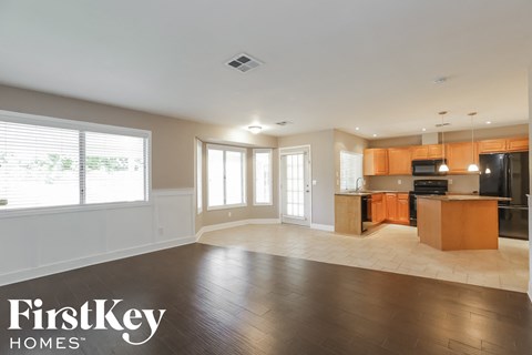 A spacious kitchen and living room with wooden floors and a large island.