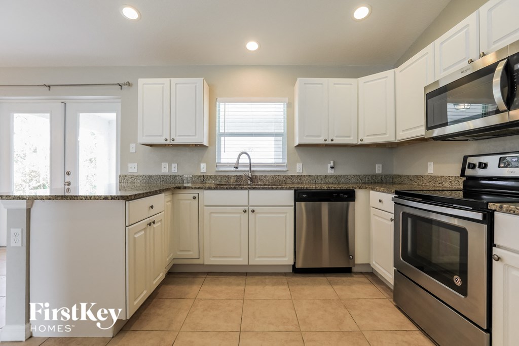 a kitchen with white cabinets and stainless steel appliances