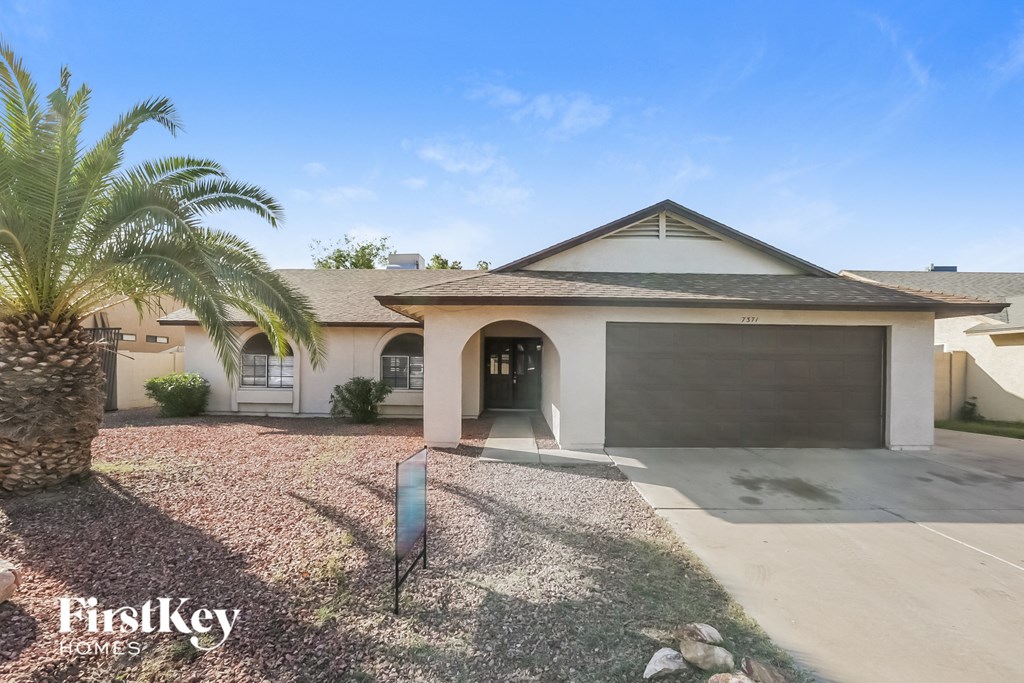 A house with a palm tree in front and a sign that says "FirstKey Homes".
