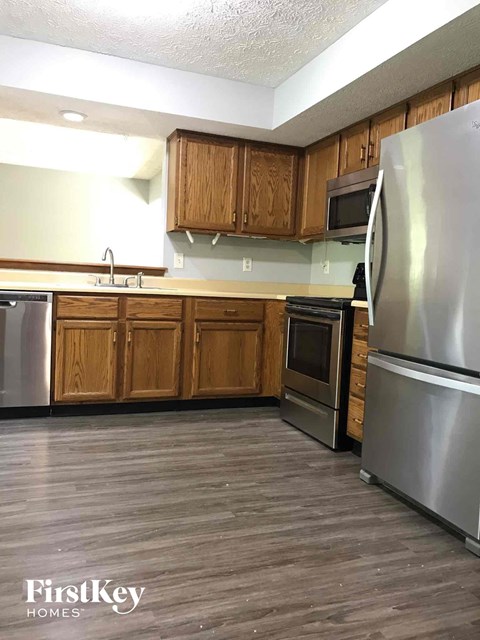 a kitchen with wooden cabinets and stainless steel appliances