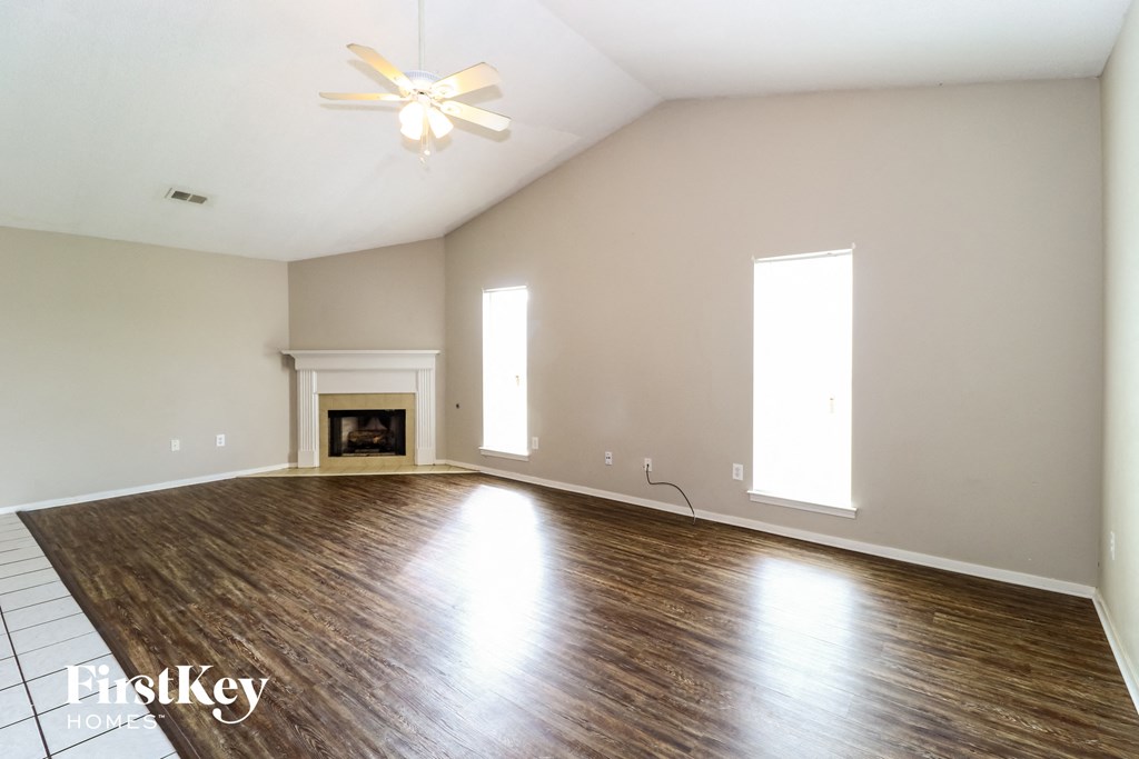 the living room with wood flooring and a fireplace