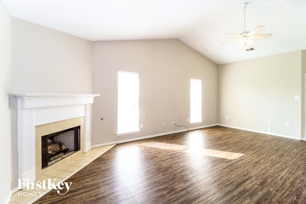 a living room with a fireplace and wooden floors