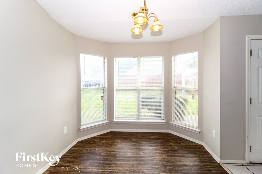 a living room with large windows and a wood floor