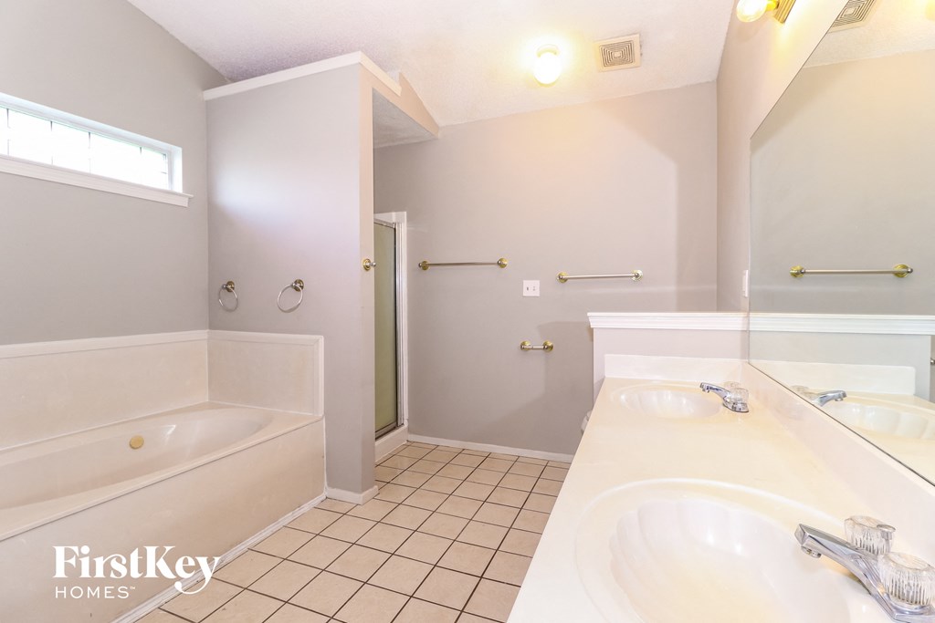 a bathroom with a tub and a sink and a mirror