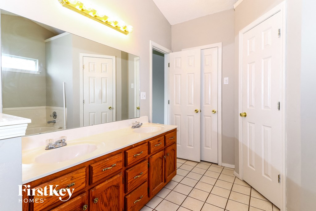 a bathroom with a sink and a mirror and two doors