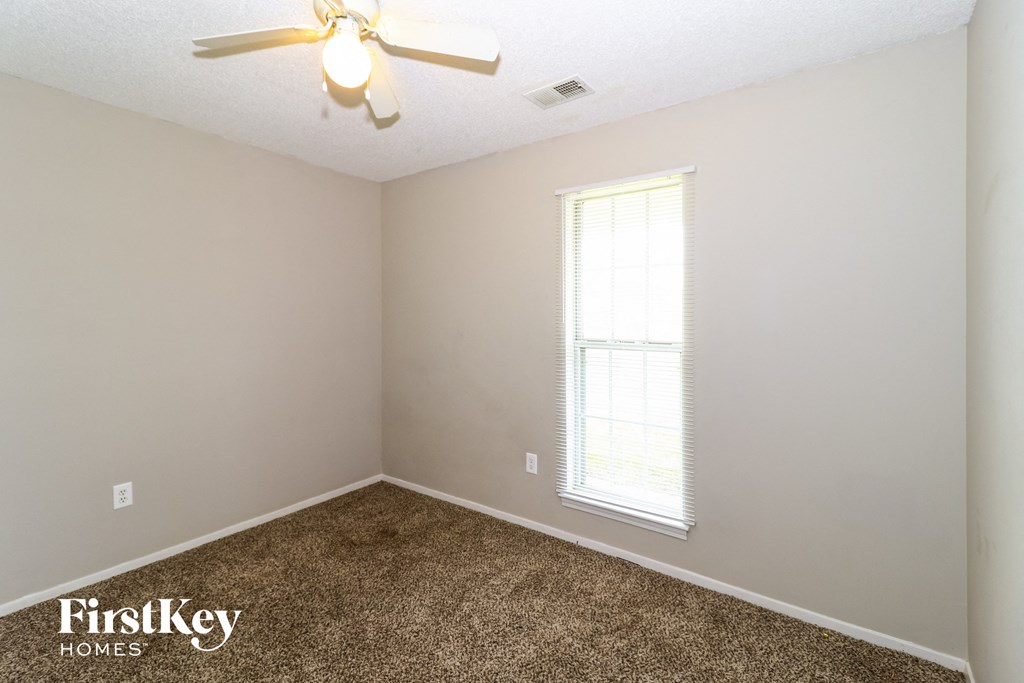 a bedroom with carpet and a ceiling fan