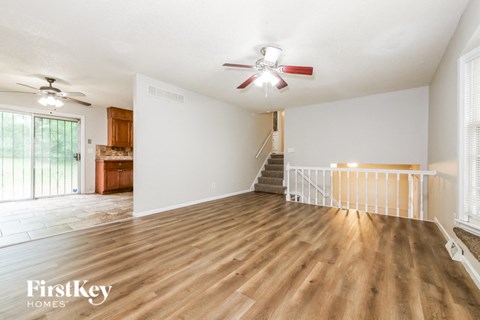 a living room with wood flooring and a ceiling fan