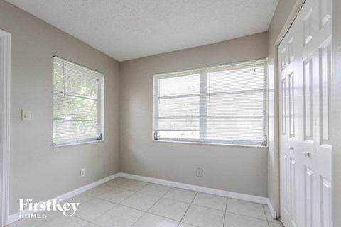 an empty room with two windows and a white door