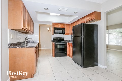a kitchen with black appliances and wooden cabinets