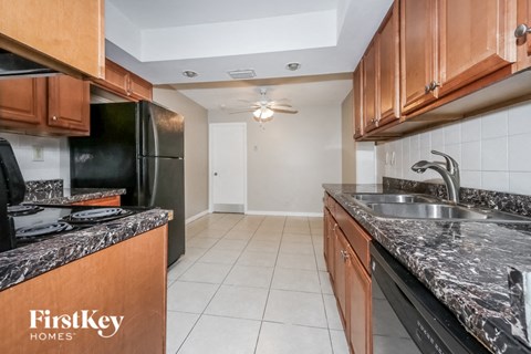 a kitchen with granite counter tops and a sink and a refrigerator