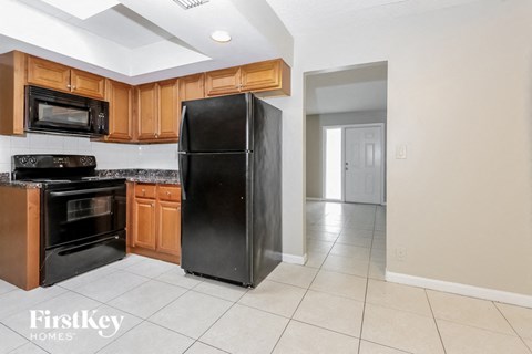 a kitchen with black appliances and wooden cabinets