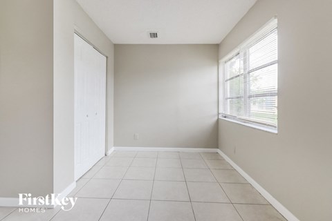 an empty living room with a large window and a door to a closet