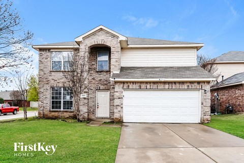 the front of a brick house with a white garage door