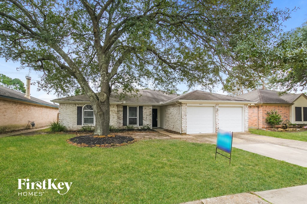 a house with a yard and a blue sign in front of it