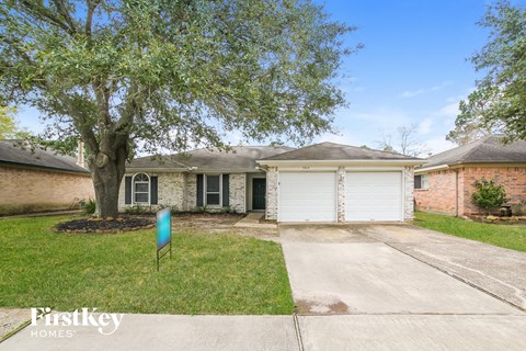 a white garage door in front of a brick house