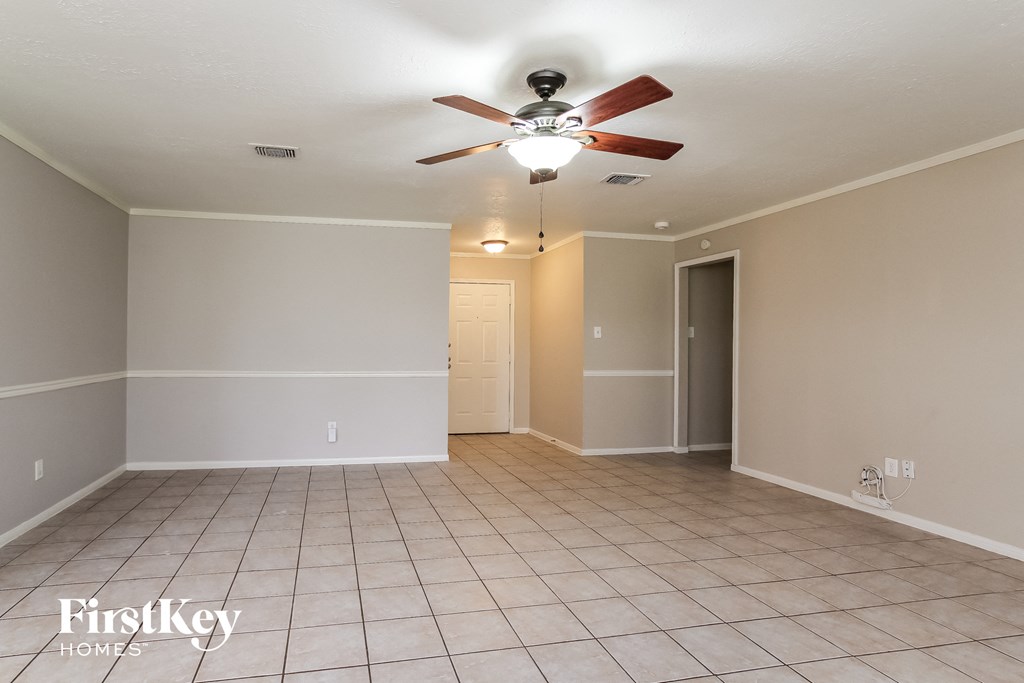 a living room with a ceiling fan and a tiled floor