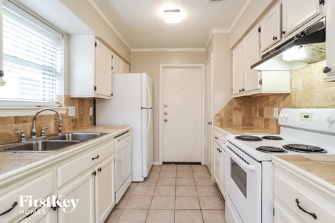 a kitchen with white appliances and white cabinets
