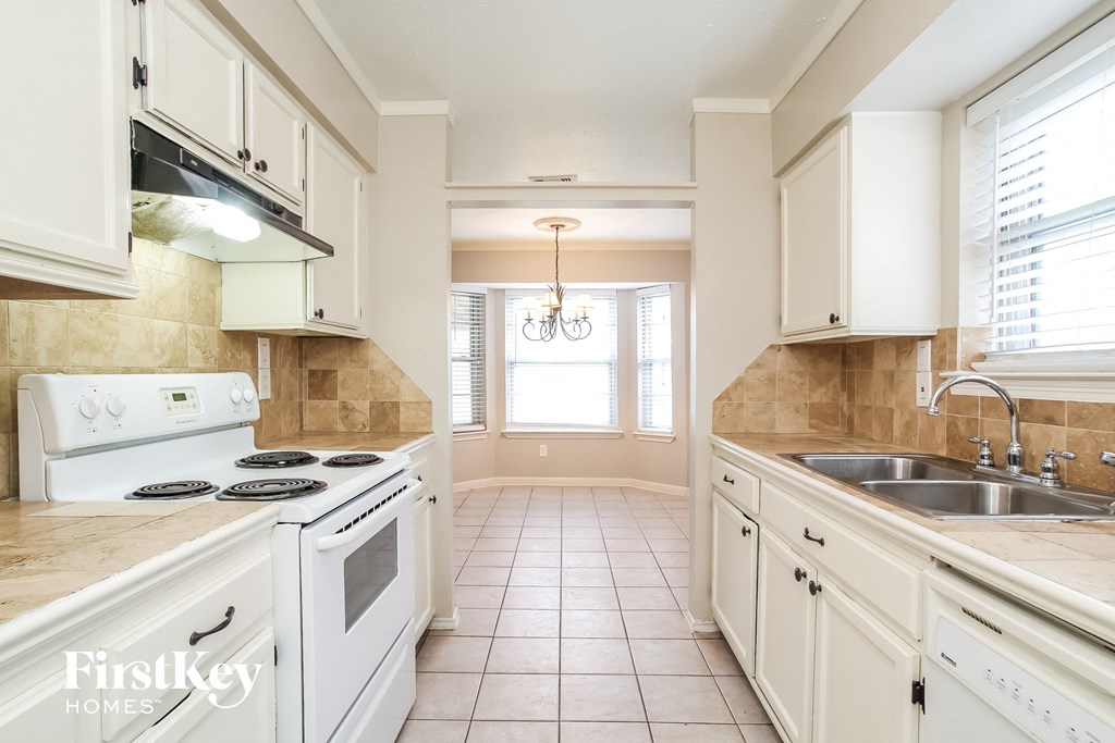 a kitchen with white appliances and white cabinets