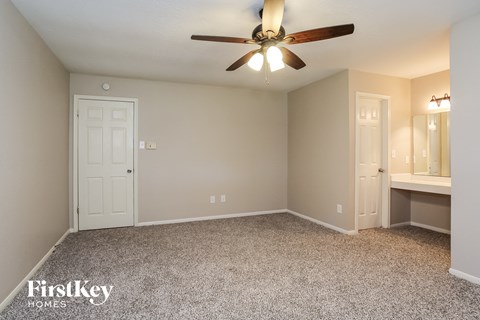 the living room of an empty house with a ceiling fan