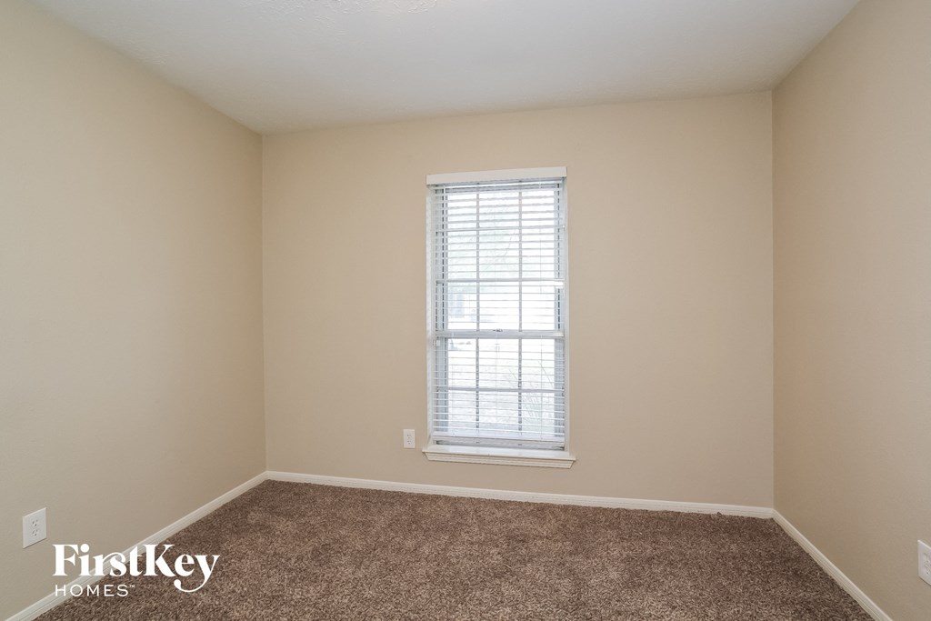 a empty room with a window and carpet