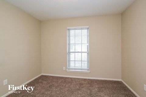 a empty room with a window and carpet