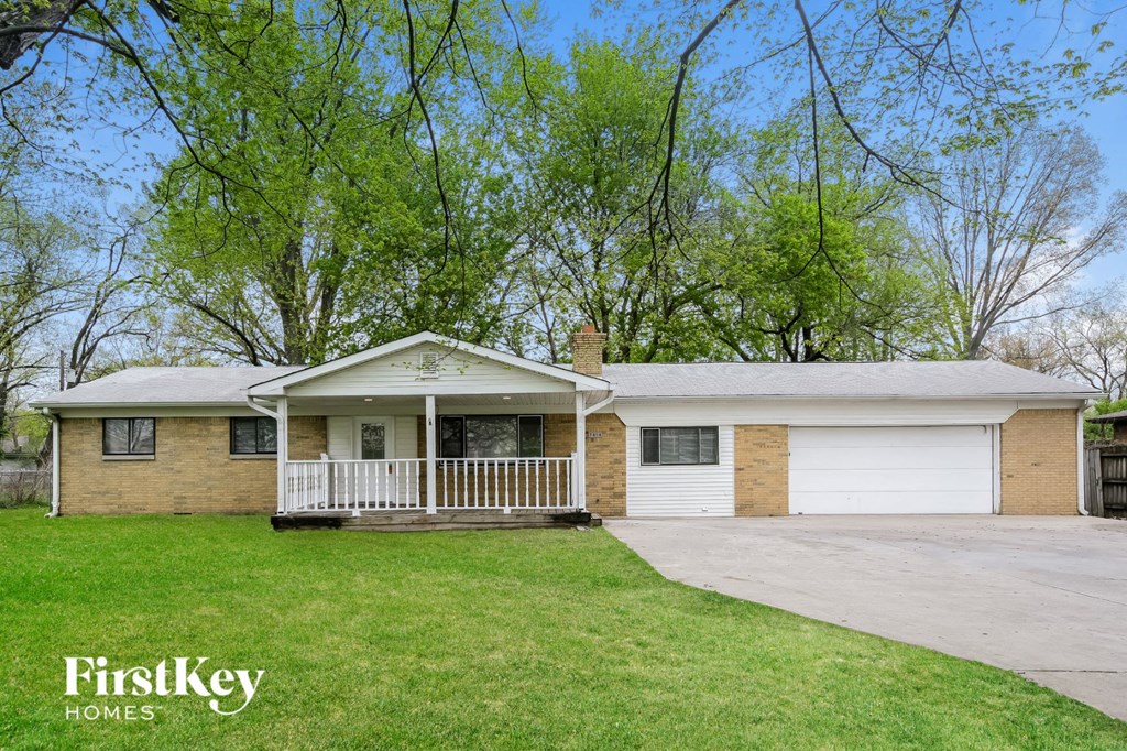 a brick house with a porch and a white garage door