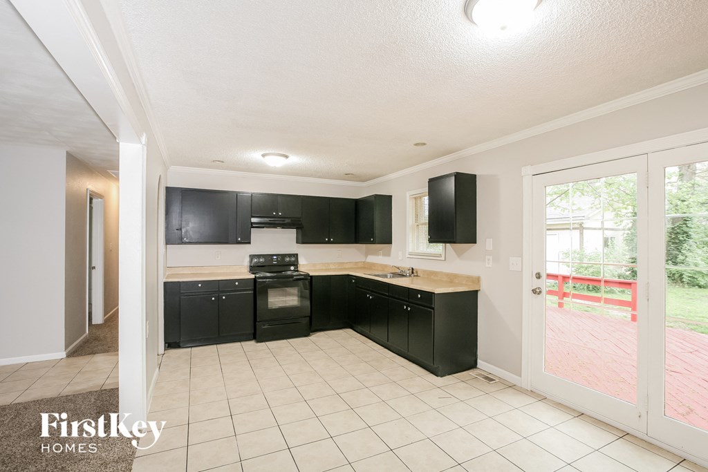 a kitchen with black cabinets and a white tile floor
