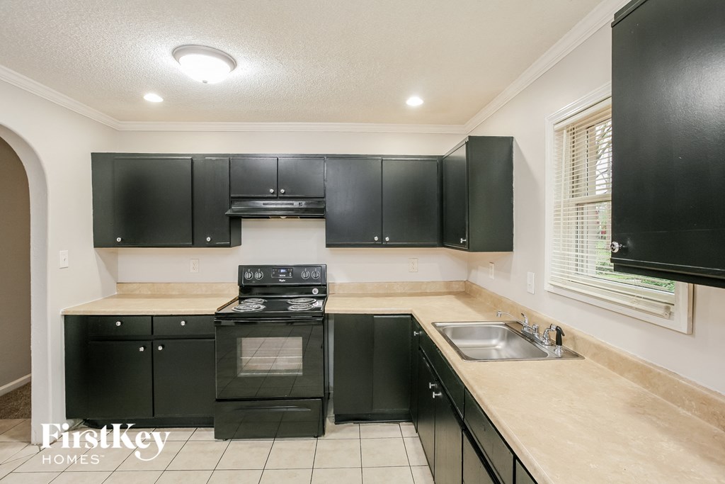 a black and white kitchen with black appliances and black cabinets