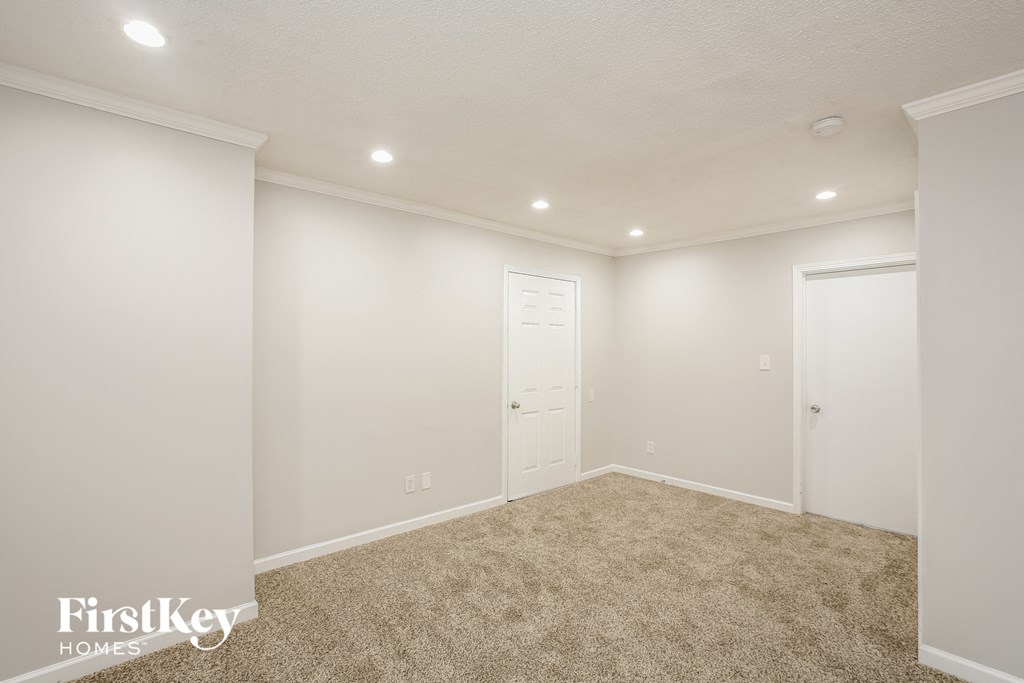 a room with white walls and carpet and a white door
