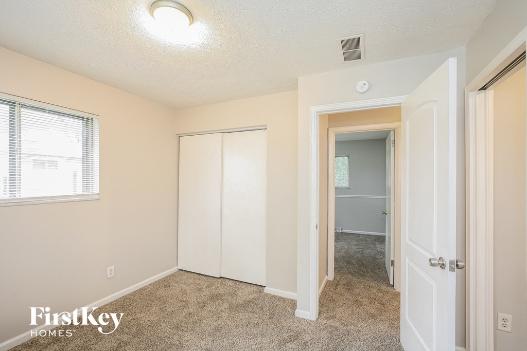 a bedroom with a closet and a door to a hallway