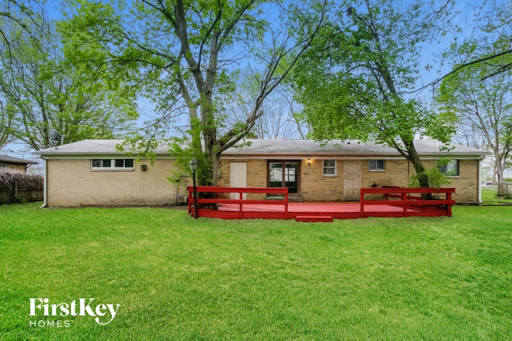a red deck in front of a brick house