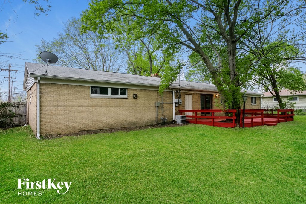 a brick house with a red fence and a tree