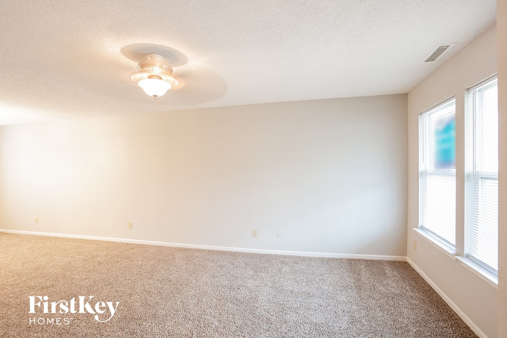 A room with a carpet floor and a light on the ceiling.