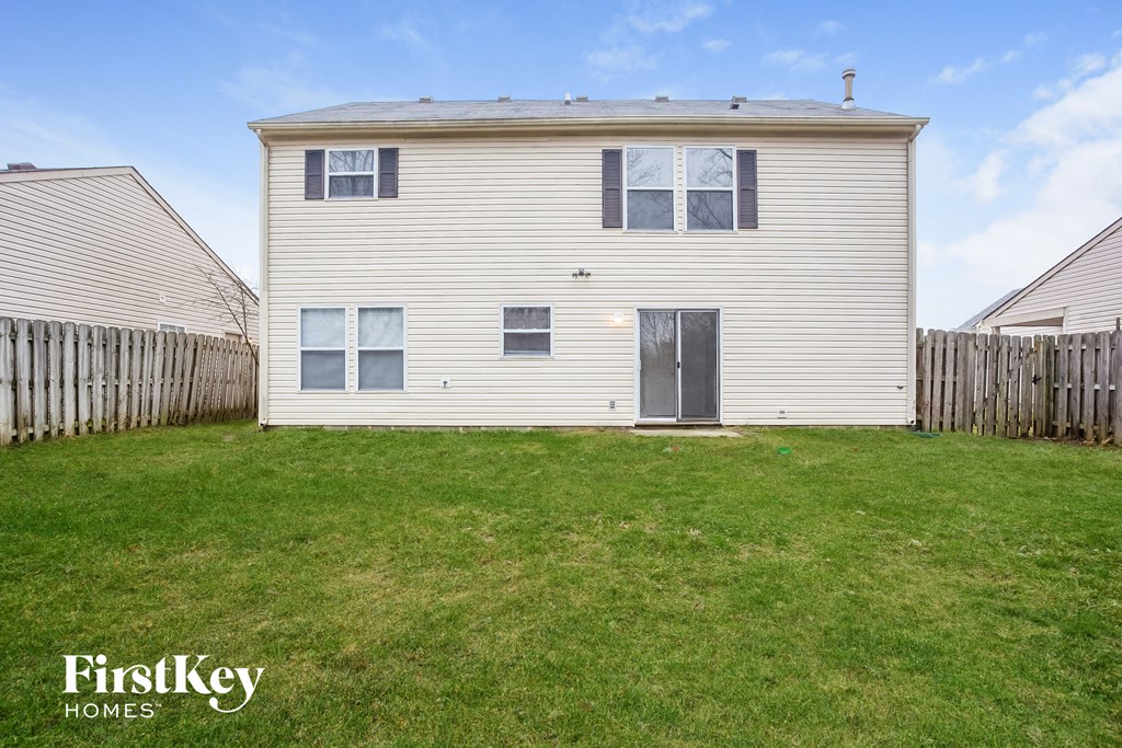 A two-story house with a grey exterior and a grey door is for sale.