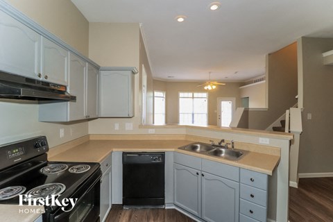 A kitchen with a stove top oven and a dishwasher.