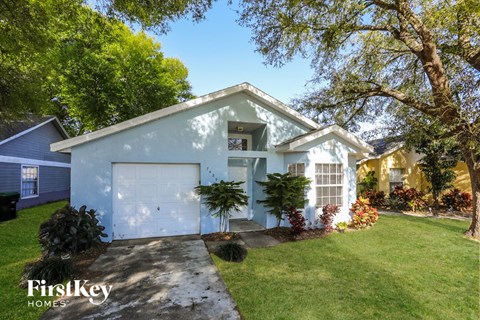 a blue house with a white garage door and a lawn
