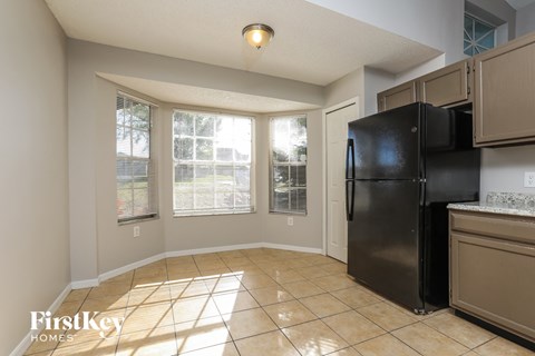 a kitchen with a black refrigerator and a window