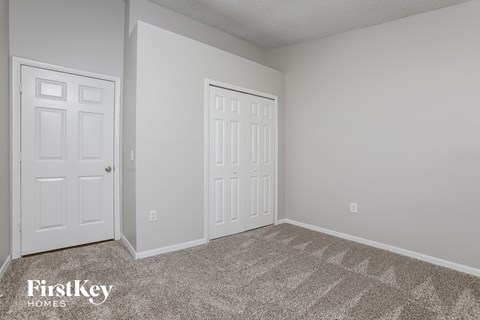 a bedroom with two white doors and a carpeted floor