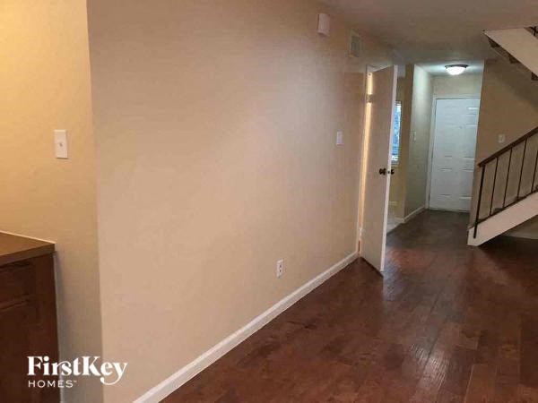 A hallway with wood floors and white walls.