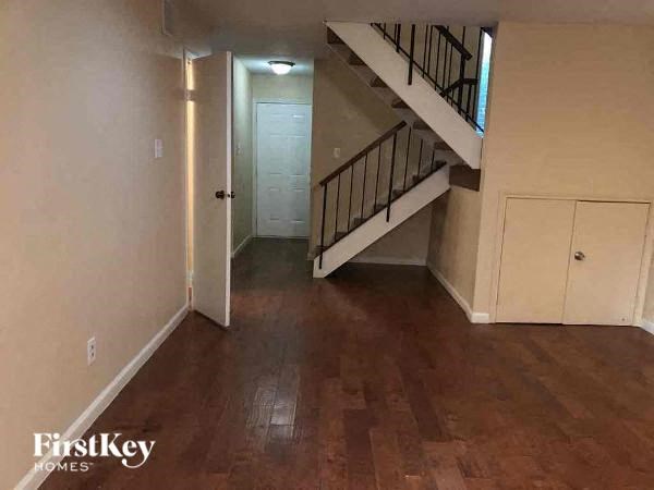 A wooden floor leads to a staircase in a house.