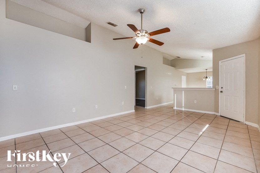 A spacious room with a ceiling fan and tiled flooring.