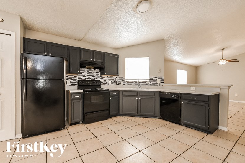 A kitchen with black appliances and cabinets is for sale.